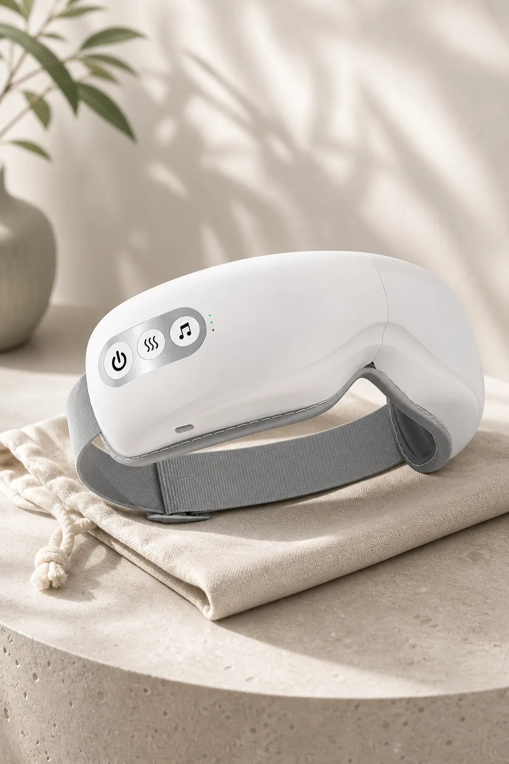 Ocuvela eye massager resting on a linen travel pouch